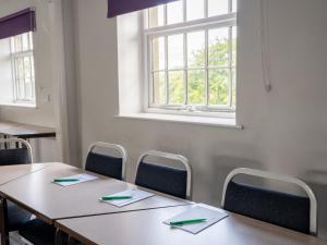 a table and chairs in a room with a window at YHA Hartington Hall in Hartington