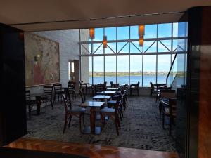 a dining room with tables and chairs and a large window at Residence on Langley Park in Perth
