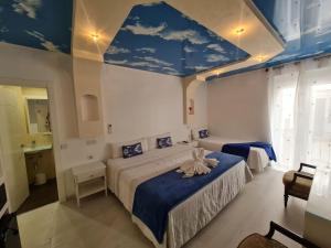 a bedroom with a large bed with a blue ceiling at Hostal Palacio Madrid in Madrid +79 photos