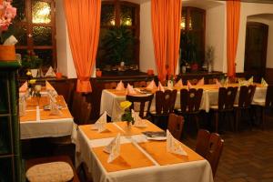 a row of tables in a restaurant with orange curtains at Landgasthof Hotel Zum Roß Dorfgütingen in Feuchtwangen +8 photos