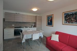 a kitchen with a table and a red couch at Nonna Leni - Rooms & Apartments in Frisanco