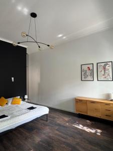 Un dormitorio con una cama y una cómoda. en Kobylianska Apartments, en Chernivtsi