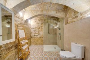 a stone bathroom with a toilet and a shower at Ta' Zaren Townhouse, Siggiewi in Siġġiewi +9 photos