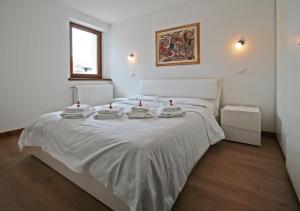 a bedroom with a white bed with towels on it at Nonna Leni - Rooms & Apartments in Frisanco