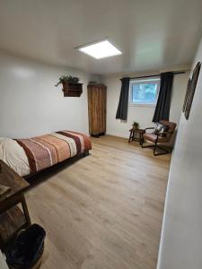 a bedroom with a bed and a chair and a window at Bed & Breakfast Twekkelo in Enschede
