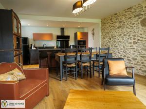 a kitchen and living room with a bar and chairs at "La maison d'Octavie" in Rieupeyroux
