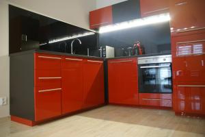 kuchnia z czerwonymi szafkami i kuchenką w obiekcie Apartamenty Viniarnia w Zielonej Górze