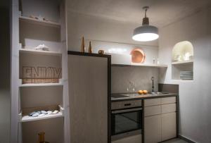 Una cocina con gabinetes blancos y un horno de estufa. en Cosmopolis Crete Suites, en Hersonissos 17 fotos más