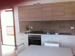 a kitchen with white cabinets and a sink at Nonna Leni - Rooms & Apartments in Frisanco