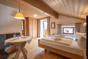 a bedroom with a large bed and a table at Beim Nuihausa in Reit im Winkl +106 photos