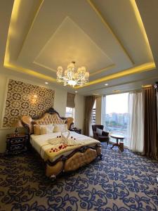 Ðông KhêにあるPhạm Hà Hotel HP - by BAY LUXURYの大きなベッドとシャンデリアのある寝室