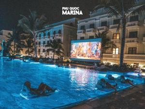 een zwembad in een hotel met mensen in het water bij JOLLIE HOTEL Phú Quốc in Phu Quoc