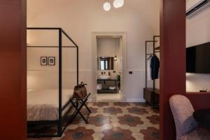 a bedroom with a canopy bed and a living room at Carmela Homes & Residences in Catania