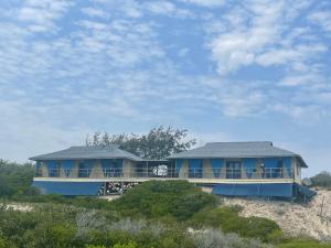a large blue house on a beach at Izmaan Lodge Pomene in Fombeni