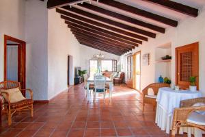 a living room with a table and chairs and a ceiling at Finca Tossalet. Piscina privada y barbacoa in Benissa