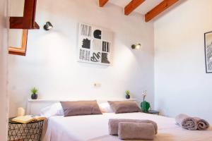 a bedroom with two beds with white walls at Finca Tossalet. Piscina privada y barbacoa in Benissa