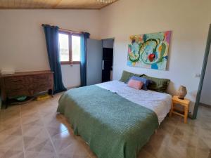 a bedroom with a bed and a painting on the wall at La Maison de Blu in Lorgues