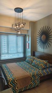 a bedroom with a large bed and a clock on the wall at Studio Premier Suite Makatii by Christine Suites PH in Manila +20 photos