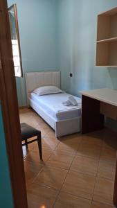 a bedroom with a bed and a table and a chair at Trumpets Apartment in Tirana