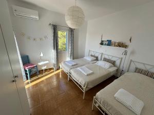 Agios GeorgiosにあるVilla Blueのベッドルーム1室(ベッド2台、テーブル、ランプ付)