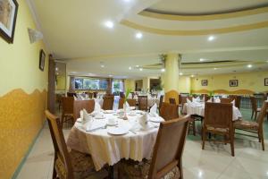 un restaurante con mesas y sillas con mantel blanco en Mbale Resort Hotel, en Mbale