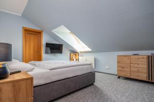 欧巴德伍斯图ALTES WASSERWERK Whg. AW-24的一间卧室配有一张床和一个带电视的梳妆台