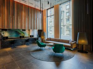 塔林Movenpick Hotel Tallinn的大楼内配有沙发和椅子的大厅