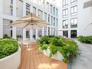 塔林Movenpick Hotel Tallinn的带桌子和遮阳伞的露台 更多37张照片