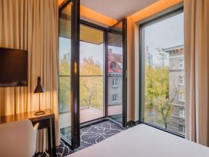塔林Movenpick Hotel Tallinn的一间带床和大窗户的卧室