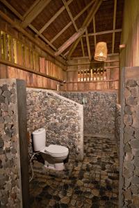 - une salle de bains avec toilettes dans un bâtiment en bois dans l'établissement Lavana Dive & Nature Resort, à Unauna
