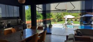 a dining room with a table and a view of a pool at Villa Obednikovski in Ljubojno