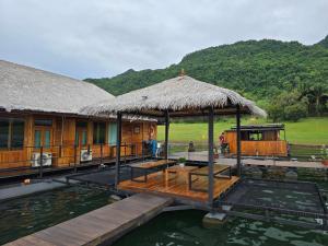 a house on the water with a dock at The Floating Lake House in Ban Pracham Mai Bon