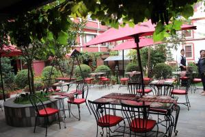 a group of tables and chairs with pink umbrellas at Hotel Encounter Nepal & Spa in Kathmandu