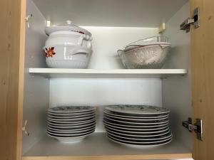 a cupboard with plates and bowls in it at Appartement Hartl in Mittersill