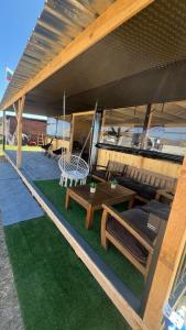 a patio with a table and a bench and a swing at Бунгало woodwave in Chernomorets