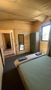 a room with a bed in a wooden cabin at Бунгало woodwave in Chernomorets