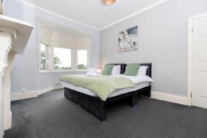 a bedroom with a large bed with green pillows at Charming and comfortable property by Our Home Short Stays very spacious with super fast WiFi close to the Metro Centre and Newcastle City Centre in Gateshead