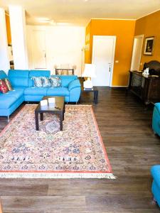 a living room with a blue couch and a rug at An exclusive NEW apartment designed for modern living with timeless style in Bellano