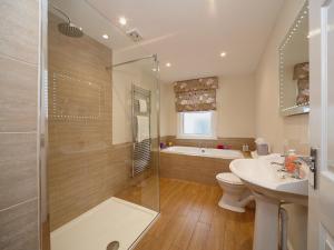 a bathroom with a tub and a toilet and a sink at The Old Stables in Filey