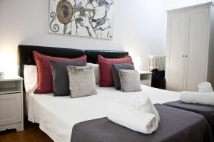 a bedroom with a large white bed with colorful pillows at Petit Hotel in Barcelona