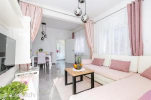 a living room with a white couch and a table at Apartment Radalj in Kaštela