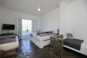 a white room with two beds and a television at Kea Island II in Korissia
