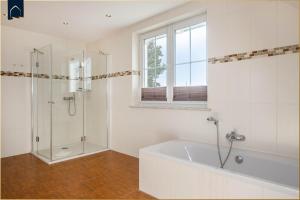 a white bathroom with a tub and a shower at Ferienhaus Ulme in Kachlin +18 photos