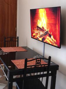 a tv hanging on a wall with a fireplace at Makao in Kilifi