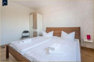 a bedroom with a white bed with towels on it at Ferienwohnung Sonneneck in Kachlin