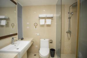 a bathroom with a toilet and a sink and a shower at Sanya Xintai Seaview Hotel in Oujiayuan