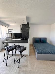 a bedroom with a bed and two chairs in it at Beau studio dans résidence avec piscine et vue sur la ville - 5min des plages in Mandelieu-La Napoule