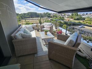 a balcony with wicker chairs and a table on a balcony at ROOF TOP 50m2 VUE MER !! à 2 mn à pied de la PLAGE et de la THALASSOTHERAPIE ! in Concarneau