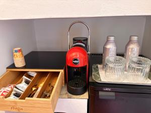 a kitchen counter with a red appliance in a drawer at Taorminas Sun Central Boutique Guesthouse & Suites in Taormina