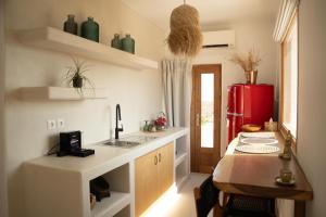 a kitchen with a sink and a red refrigerator at Divino Caldera in Akrotiri